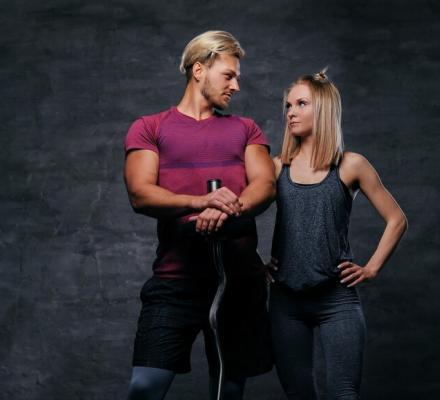 blond-female-holds-dumbbells-grey