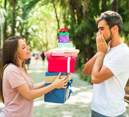 woman-giving-stack-gifts-her-surprised